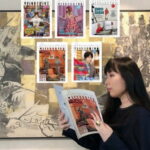 Portrait photographique de Eru Gibson, rédactrice en chef de danran, lisant un numéro de son magazine devant une grande peinture murale d'art contemporain. Plusieurs autres couvertures de danran sont affichées sur le mur derrière elle.