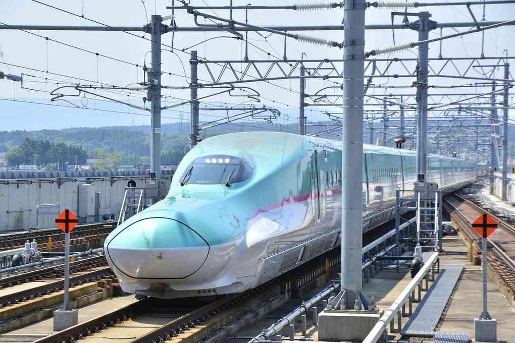 Train à grande vitesse blanc bleu arrêté quai gare avec caténaires électriques Train à grande vitesse blanc bleu arrêté quai gare avec caténaires électriques